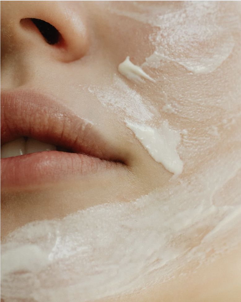 Person applicerar hudvårdsprodukter i rätt ordning – tunna serum först, följt av kräm och solskydd.