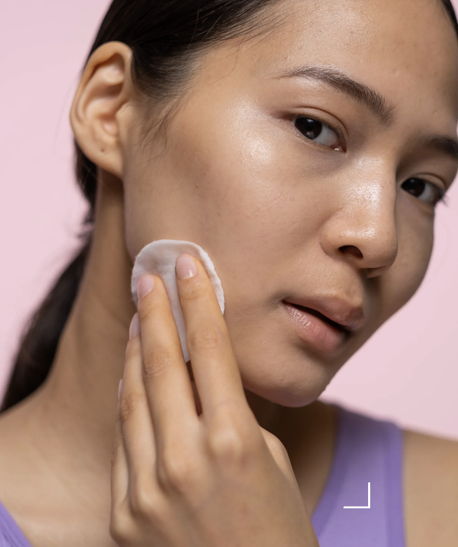 Person applicerar exfolierande hudvård på ansiktet, fokus på skonsam rutin och rätt frekvens för lyster och balans.